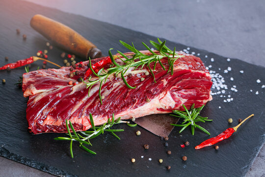 Fresh Raw Beef Flank Steak Sprinkled With Spices, Rosmairin And Chilli Pepper. On The Bridlic .