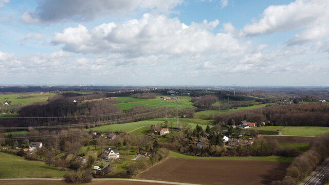 Windkraftanlage und H&ouml;S/HS Stromtrasse mit Blick von Velbert nach Essen