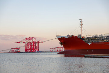 Oil tanker ship loading in port. Fuel tanker ship docked in industrial area. LPG tanker.