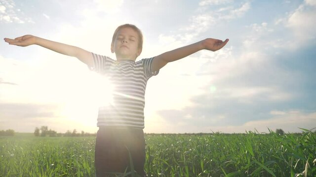 boy prays pulls hands to the sky against a blue sky. child concept faith religion and happy family lifestyle. kid son hands to the side against the blue sky jew praying to god. worship and gratitude