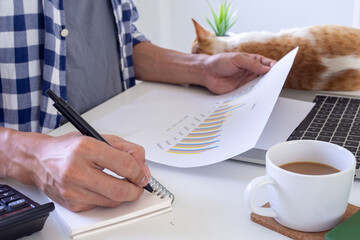 Fototapeta premium Man using a laptop at home to work or study online to prevent the spread of the virus. Work from home, study online concepts