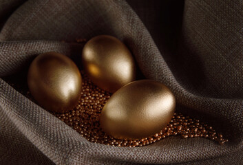 Golden eggs lie on gold sand.