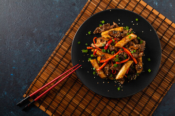 Traditional Korean Tteokbokki rice noodles with beef, vegetables and shitake mushrooms. Prepared in a wok.