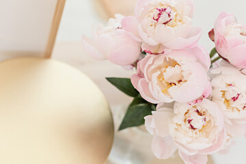 Styled composition with pink tulips on gold background. Flat lay floral frame and white textile. Border top view.