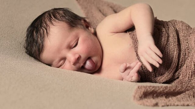 Cute infant girl lying in bed wake up close up. Looking at camera. Childhood. First days of new life