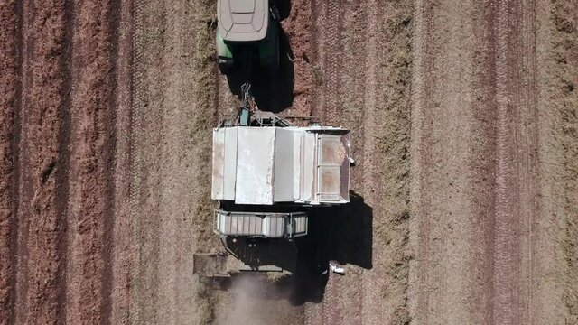 Peanut harvest done by a Tractor and Picker trailer, Aerial view.