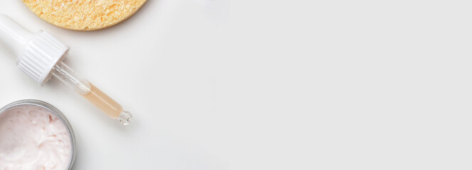 Nourishing and hydrating facial serum, antirid cream and facial sponge, top view with copy space.