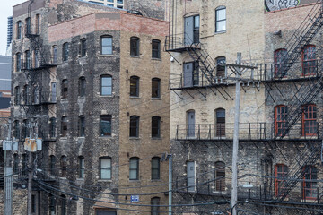 Vintage brick buildings with metal fire escapes in urban Chicago on overcast day