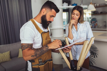 Wife helping husband to repair broken chair at home