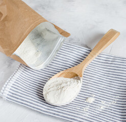 Crumbly xanthan gum in a wooden spoon.