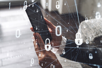 A woman programmer is browsing the Internet in smart phone to protect a cyber security from hacker attacks and save clients confidential data. Padlock Hologram icons over the typing hands. Formal wear