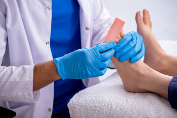 Podiatrist treating feet during procedure