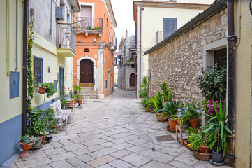 Fototapeta na wymiar A narrow street among the old houses of Venosa, a medieval village in the Basilicata region, Italy.