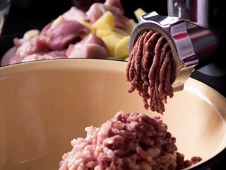Cooking minced meat in an electric meat grinder from fresh meat at home.