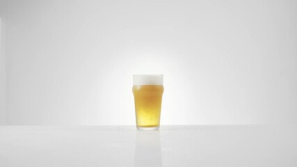 A glass of foaming beer. A pint of beer with foam. High quality 4k footage 50fps