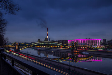 View of the colorful Bogdan Khmelnitsky bridge illuminated at night reflecting in the Moskova river at night