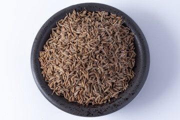 Black cumin in the cup on a white background
