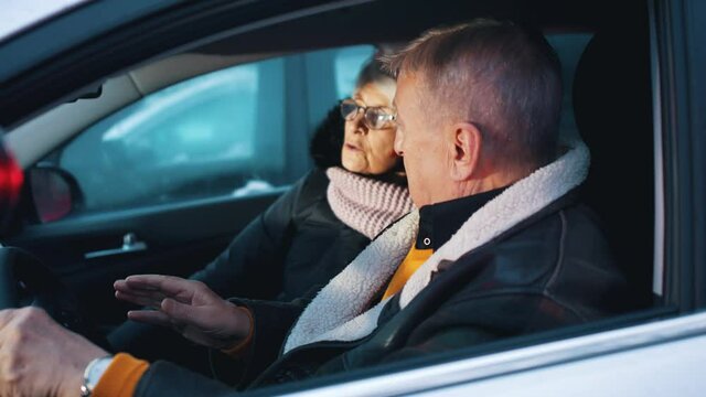 Elderly couple in the car confused with flashing police lights. Speeding ticket. Man and woman having argument in the car. High quality 4k footage