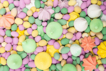 Fototapeta na wymiar Colorful meringues and glazed peanuts isolated on a white background.