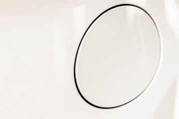 A close up of a petrol round cap cover on a modern white car