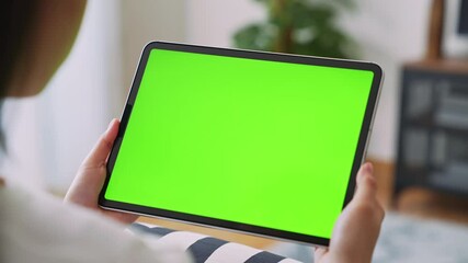 Close up of woman holding in hands a digital tablet with green screen for internet online, chroma key screen for advertising. - Powered by Adobe