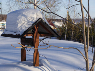 the well for water extraction is covered with snow, the roof is gable
