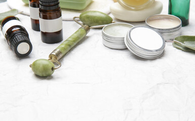 Natural organic skin care product. Home spa and self care concept. Facial serums, creams, jade roller and soap bars with copy space.