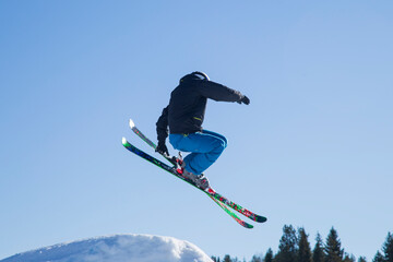 Naklejka na ściany i meble Skier skiing on the slopes of the mountain. Winter sports.