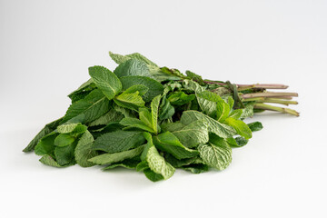 A bunch of fresh mint leaves on a white background with copy space