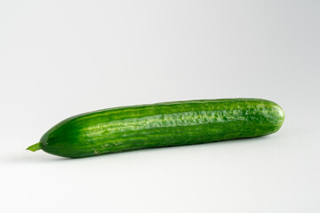 close-up of a whole fresh cucumber on a white background with copy space