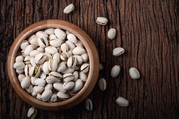 pistachio nuts on old wood background, top view. snacks and Healthy nut
