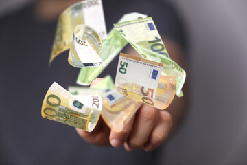 euro bills flying around  in hand