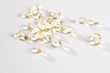 Vitamin D in the form of yellow capsules on a white background