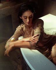 Gordijnen Serious brunette lady lying in the bathtube © konradbak