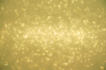 Gold glitters background. shimmering blur spot lights Bokeh Shiny gold light background.