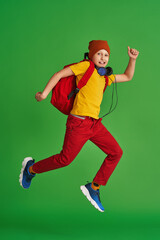 Fototapeta na wymiar cheerful schoolboy in free-style clothes, headphones, backpack and books jumps on yellow background. Dynamic images go back to conceptual school. holidays begin. Back to school. boy is ready to learn