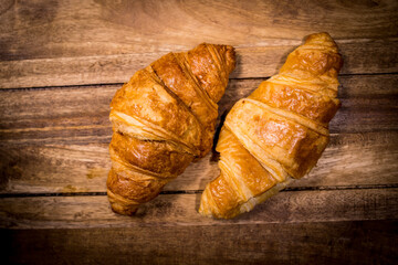 Freshly baked French croissants on a wooden table - studio photography
