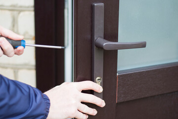 Handyman installing door lock in front door. Checking lock for operability.