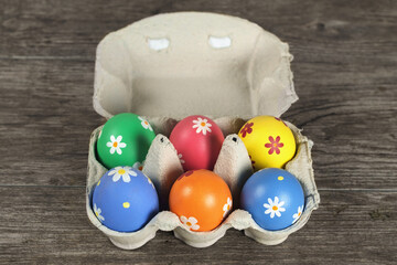 Colorful painted Easter eggs  in a paper tray on a wooden table