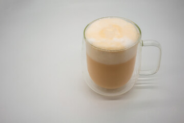 Hot Thai milk tea with milky foam sprinkle with cocoa power for decoration in double wall glass...
