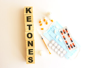 The word KETONES is made of wooden cubes on a white background. Medical concept.