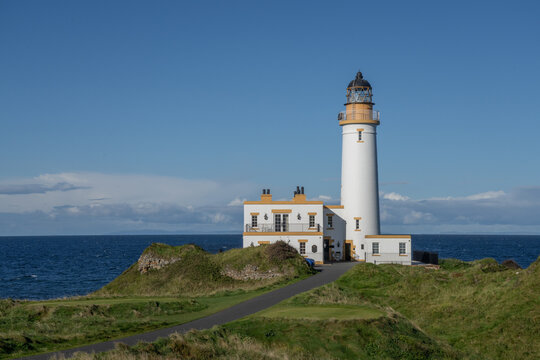 Aerial view of Turnberry Lighthouse, Scotland on a sunny day. View looking out to see over the white lighthouse on a blue sky day. 