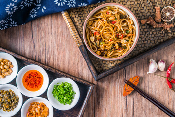 A bowl of Jiangxi Nanchang cuisine Nanchang mixed noodles placed on a wooden table 