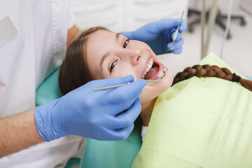 Close up of a lovely young girl smiling to the camera during dental checkup