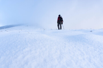 Fototapeta na wymiar Man on a snowy slope observing the scenery