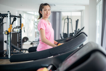 Fototapeta premium Asian women are exercising in the gym to sift through the leather water, keeping their body healthy. Premium Photo