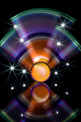 eine Glaskugel die sich im Vordergrund spiegelt, im Hintergrund bunte Lichtspuren - Lichtmalerei	