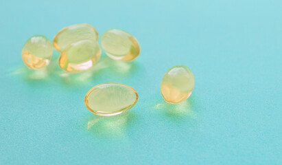 Yellow pills of fish oil on a blue background