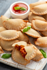 Margarita Margherita pizza parcels pockets filled with tomato, mozzarella cheese and basil served on white wooden board. Party finger food