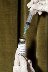 Covid-19 vaccine with syringe in the hands of unrecognizable doctor